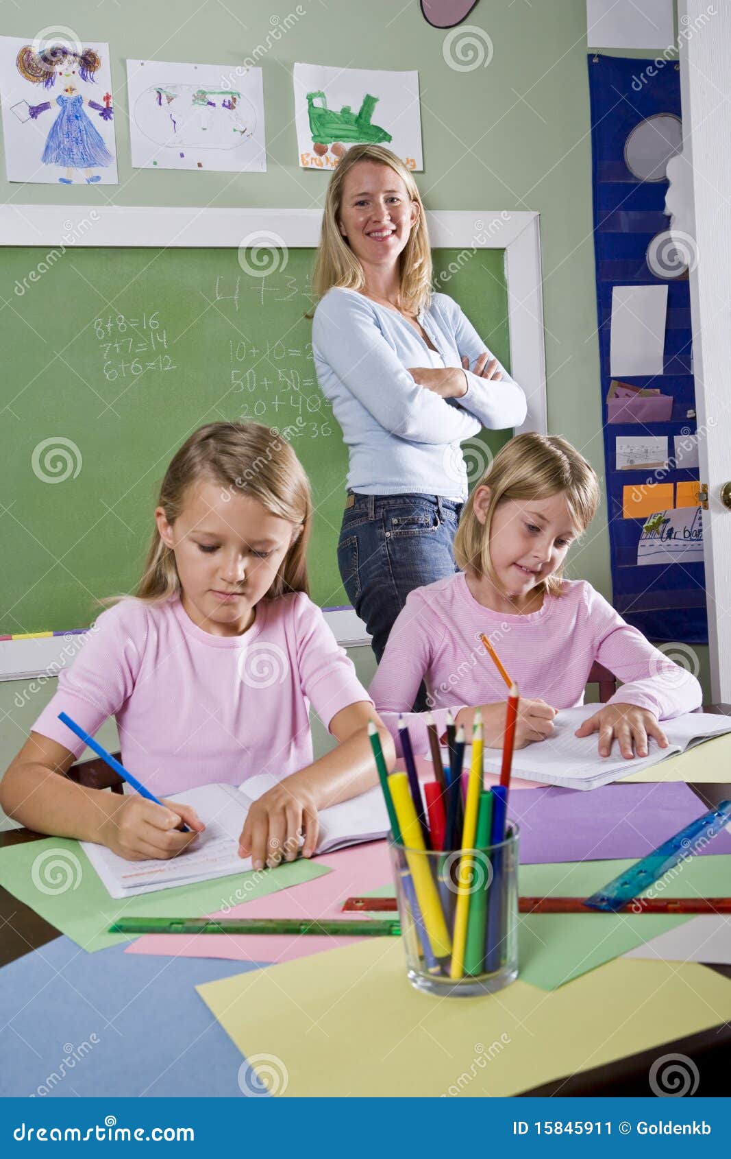 school girls writing in notebooks with teacher