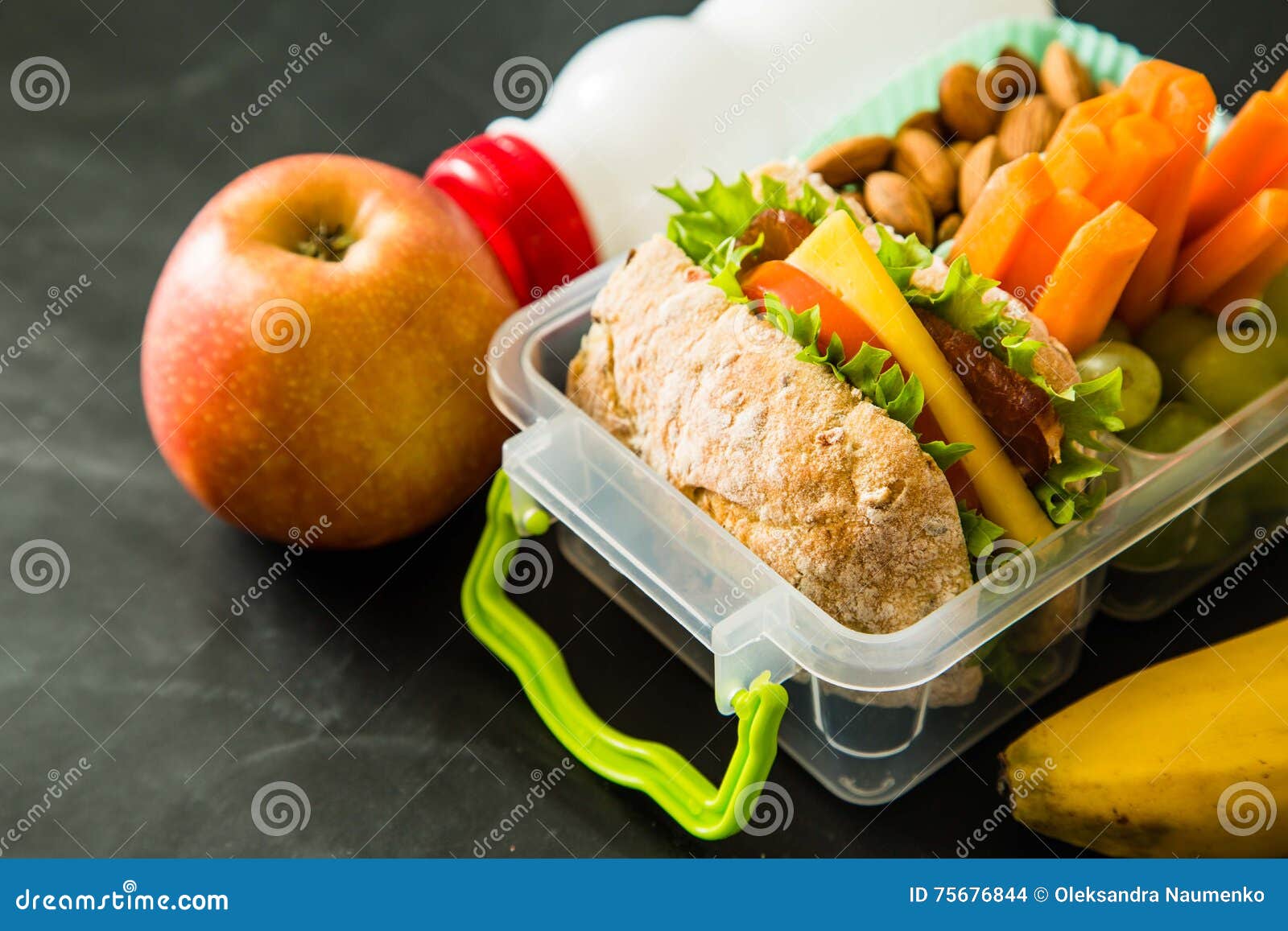 School Lunch Box with Books and Pencils in Front of Black Board Stock