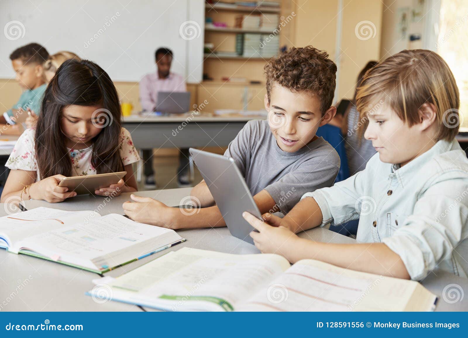 schoolboys working together with tablet computer in class