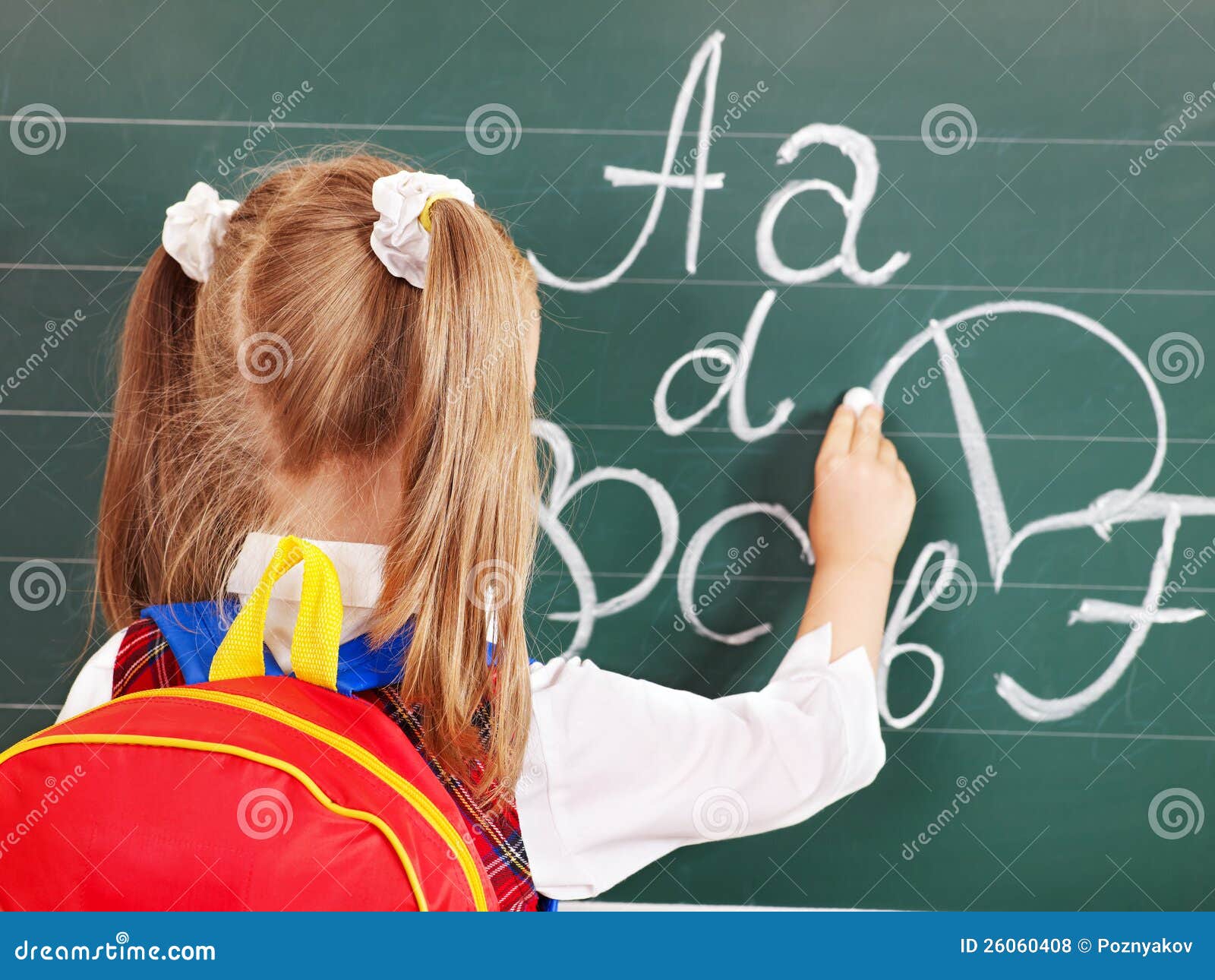 schoolchild writting on blackboard