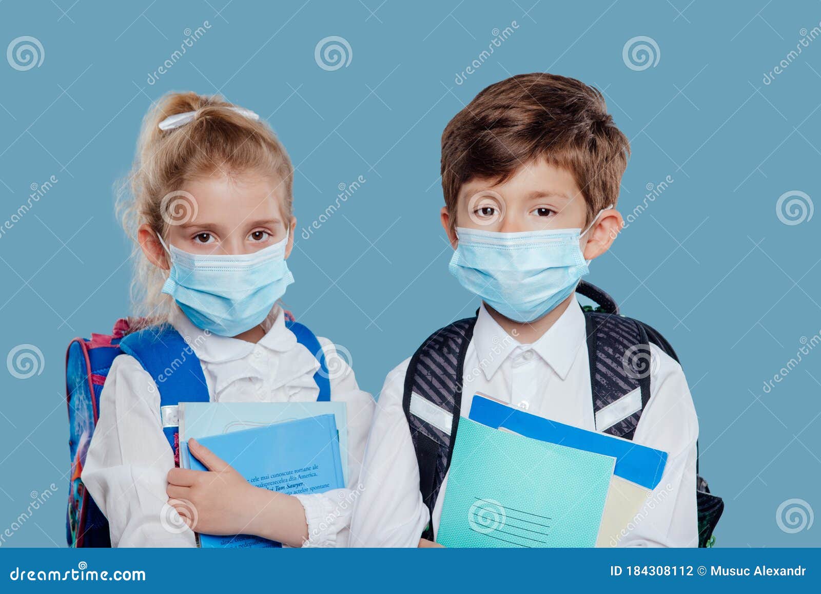 schoolchildren in face masks with copybooks during coronavirus