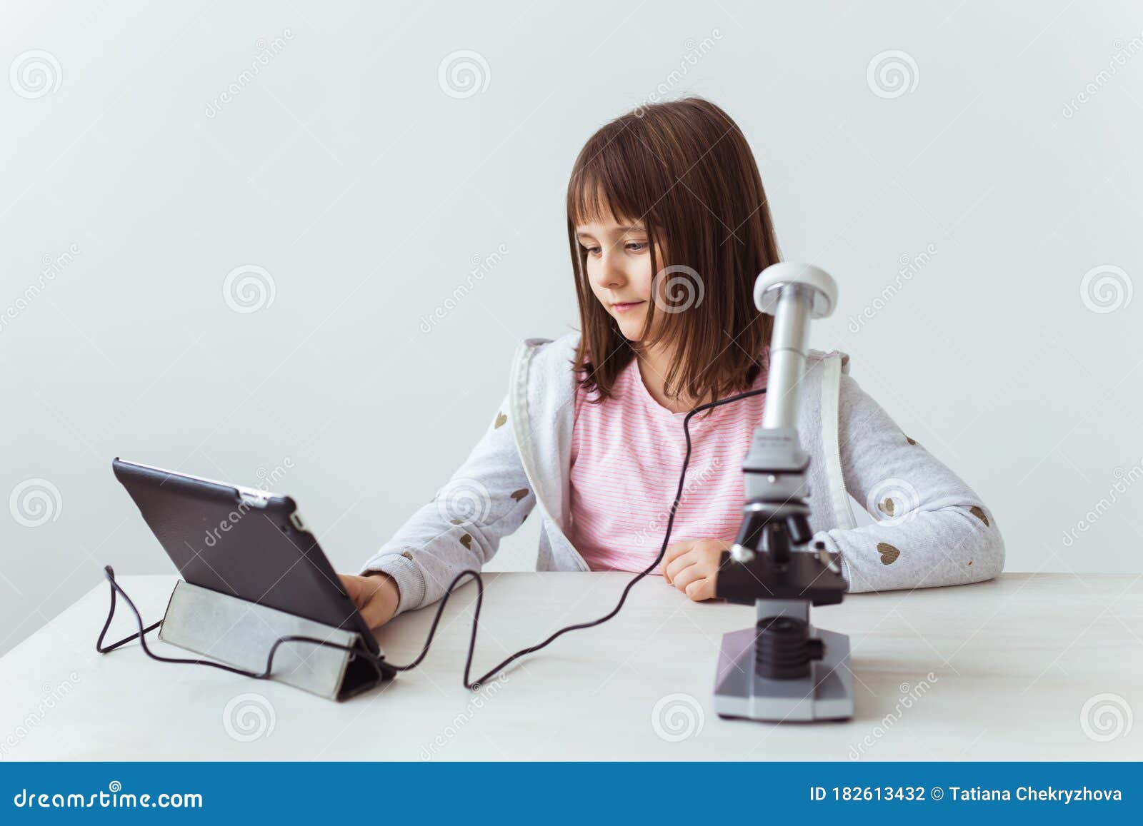 Schoolgirl Using Microscope in Science Class. Technologies, Lessons and
