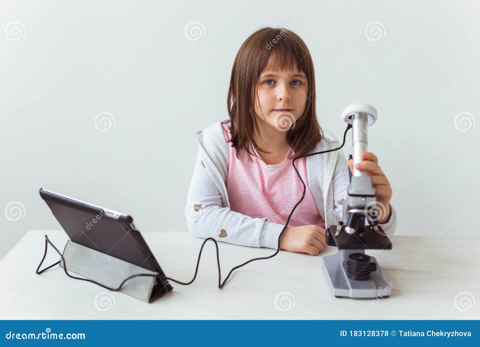 Schoolgirl Using Microscope in Science Class. Technologies, Lessons and