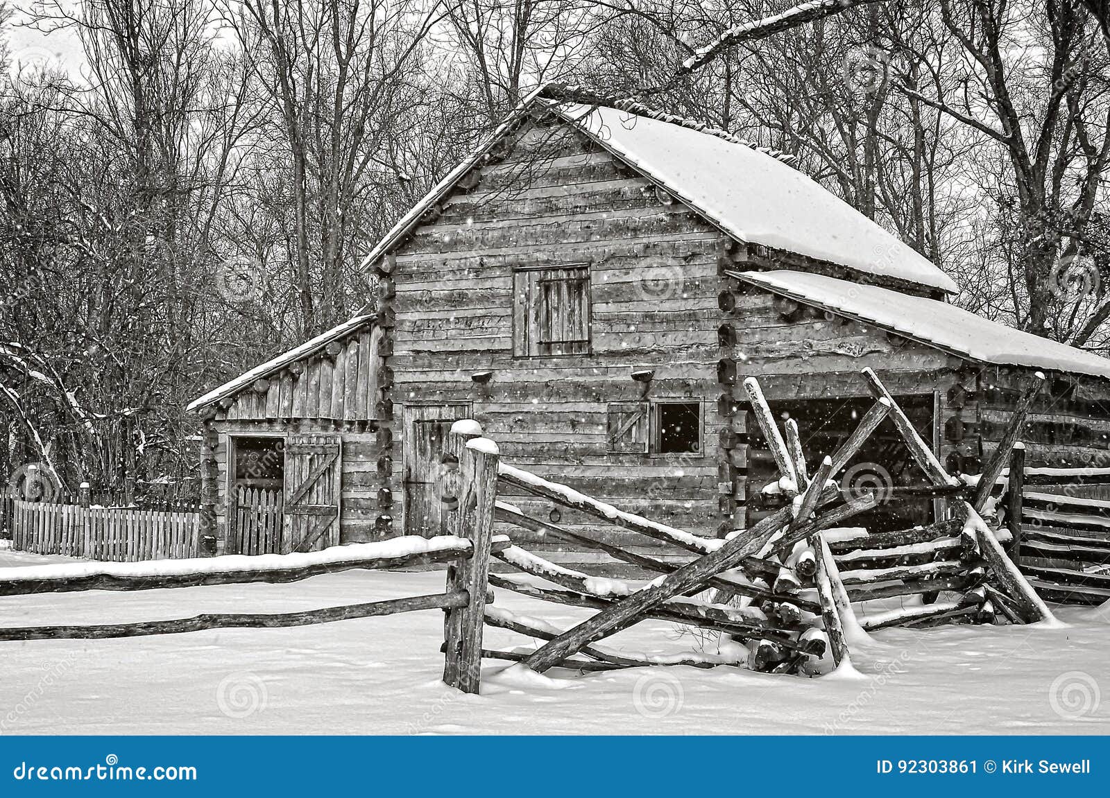 Schuur in de winter. Deze oude die schuur met logboeken wordt gebouwd bevindt zich nog in een de wintersneeuwstorm