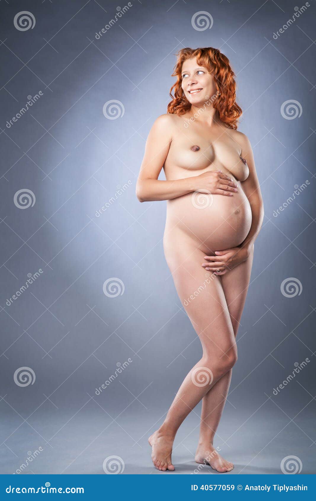 Schwangere Frau des Schönheitsaktes auf grauem Hintergrund.