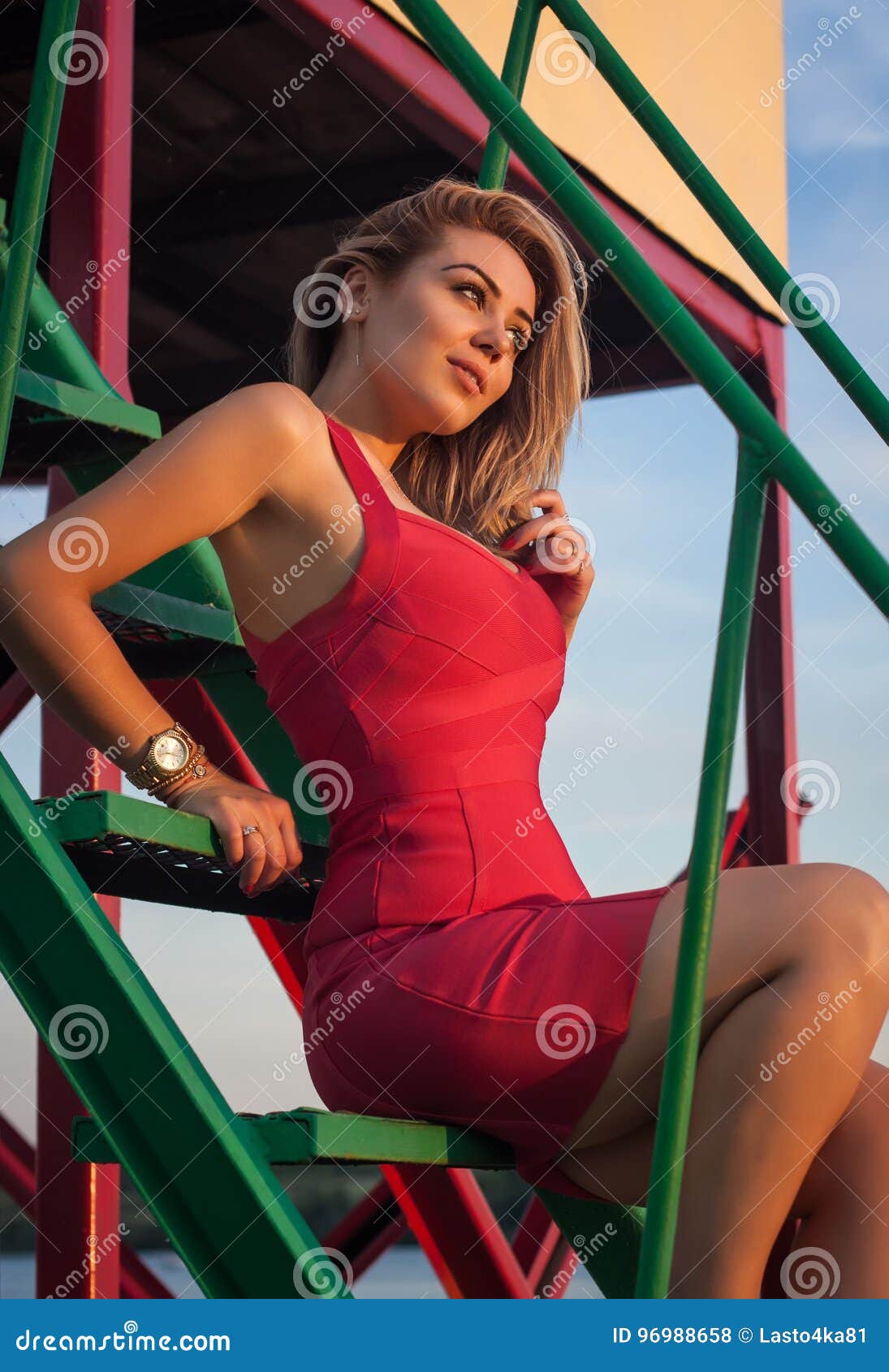 Schöne Blondine In Einem Sexy Roten Kleid Sitzt Auf Den Schritten Stockfoto Bild Von Sinnlich 