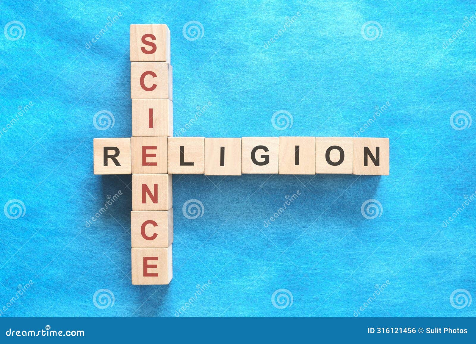 science and religion relationship and interconnection concept. crossword puzzle flat lay in blue background.