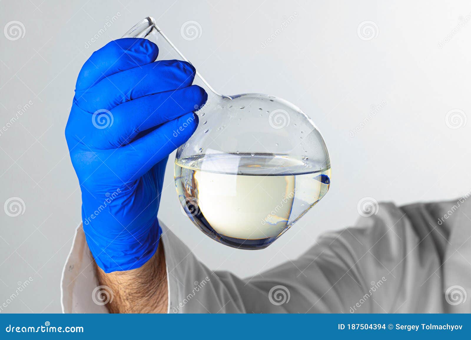 Scientist Hands Holding Some Liquid in a Glassware in Laboratory for