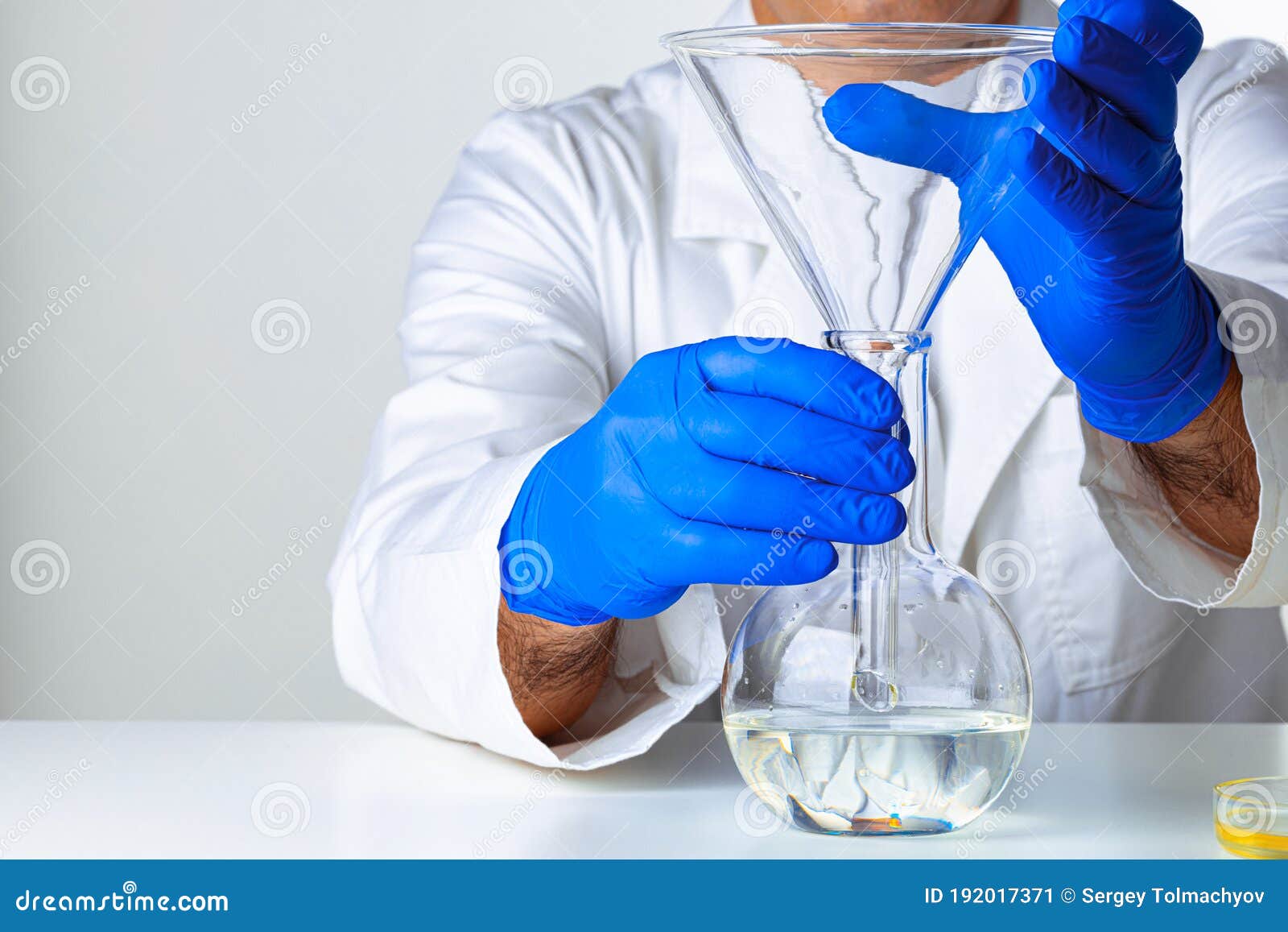 Scientist Hands Holding Some Liquid in a Glassware in Laboratory for
