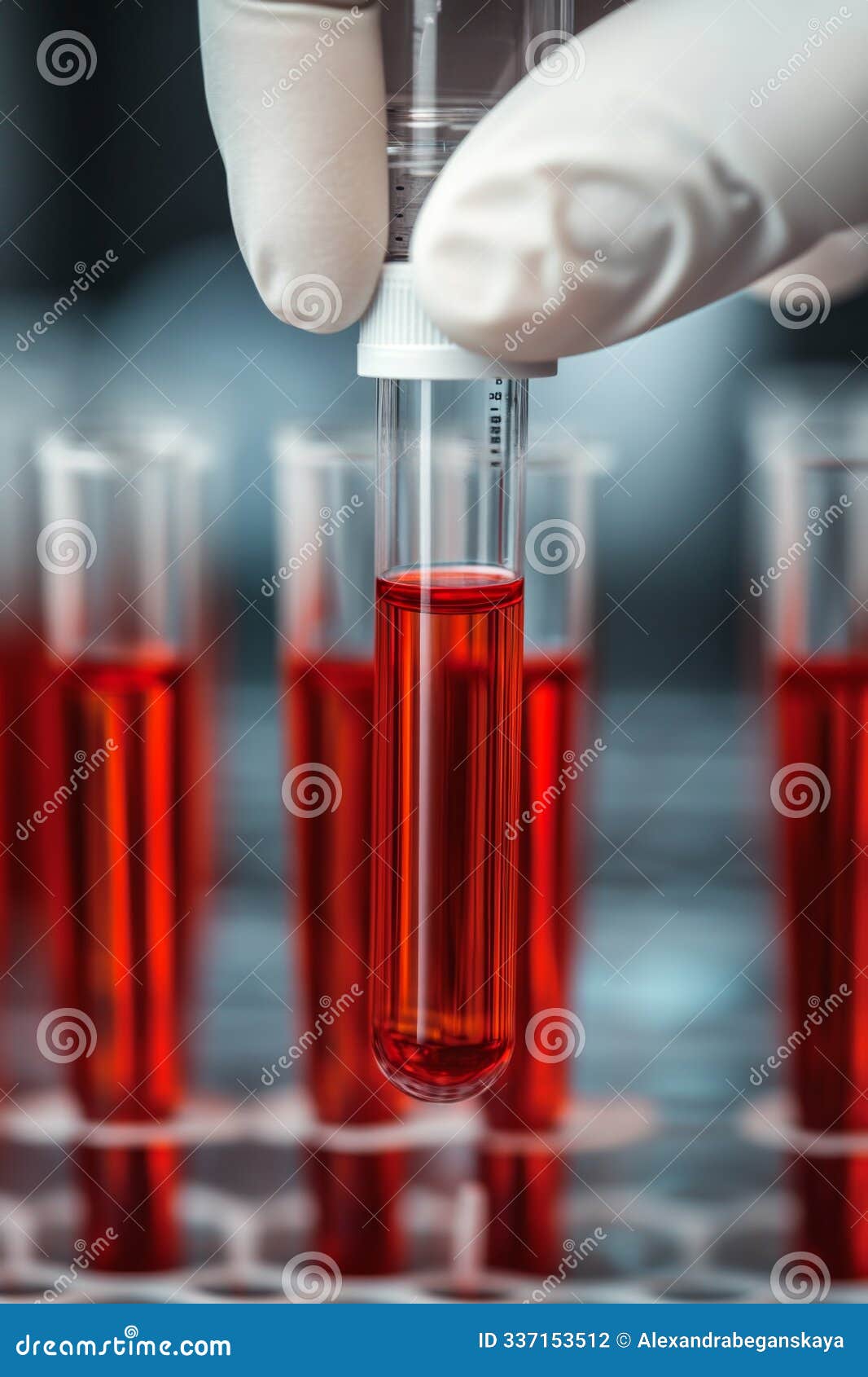 scientist holding test tube with red liquid in laboratory