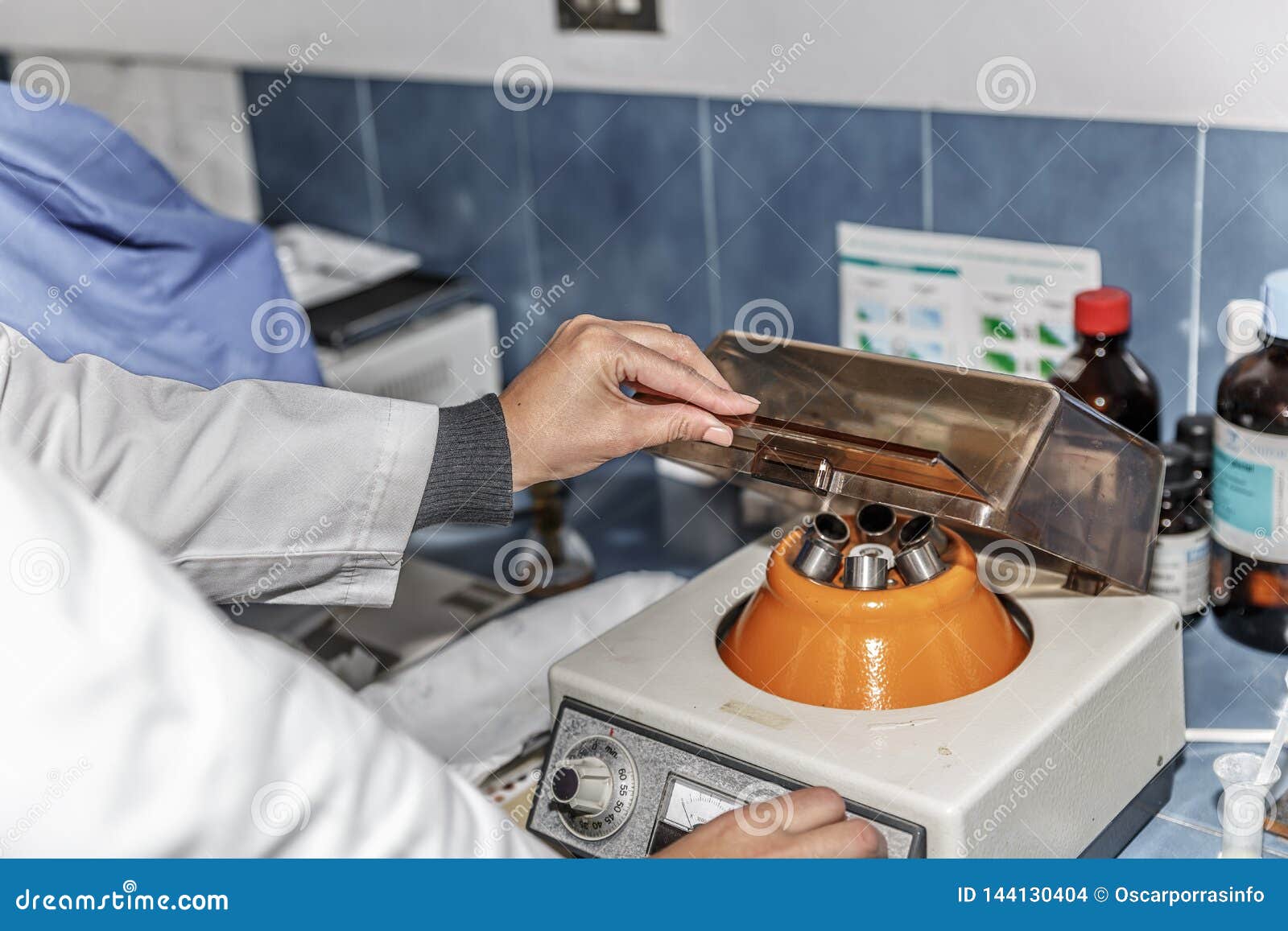 A Scientist Regulates an Agitator Machine for Test Tubes in a Lab Stock