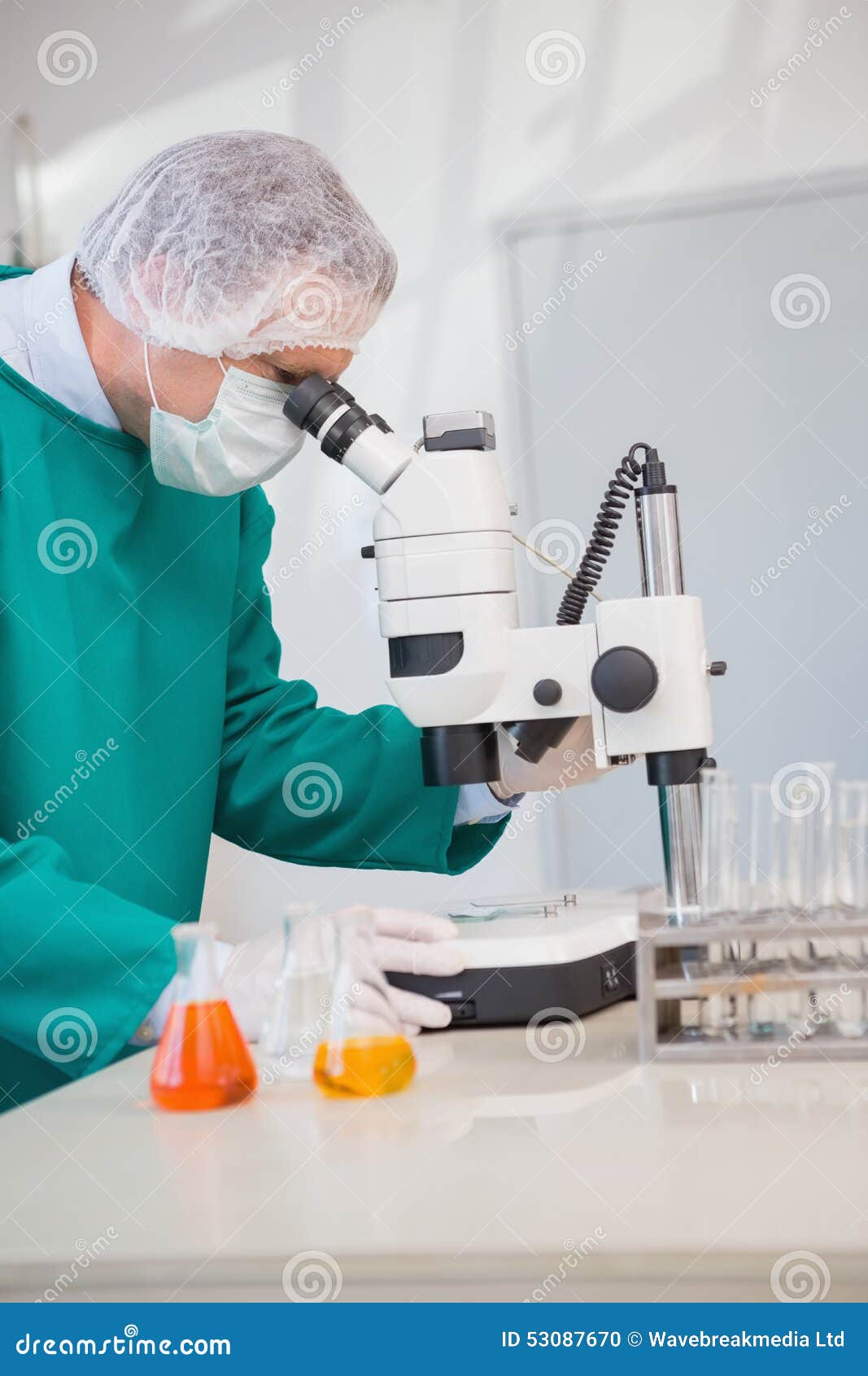 Scientist in Scrubs Using Microscope Stock Photo Image of orange, gloves 53087670