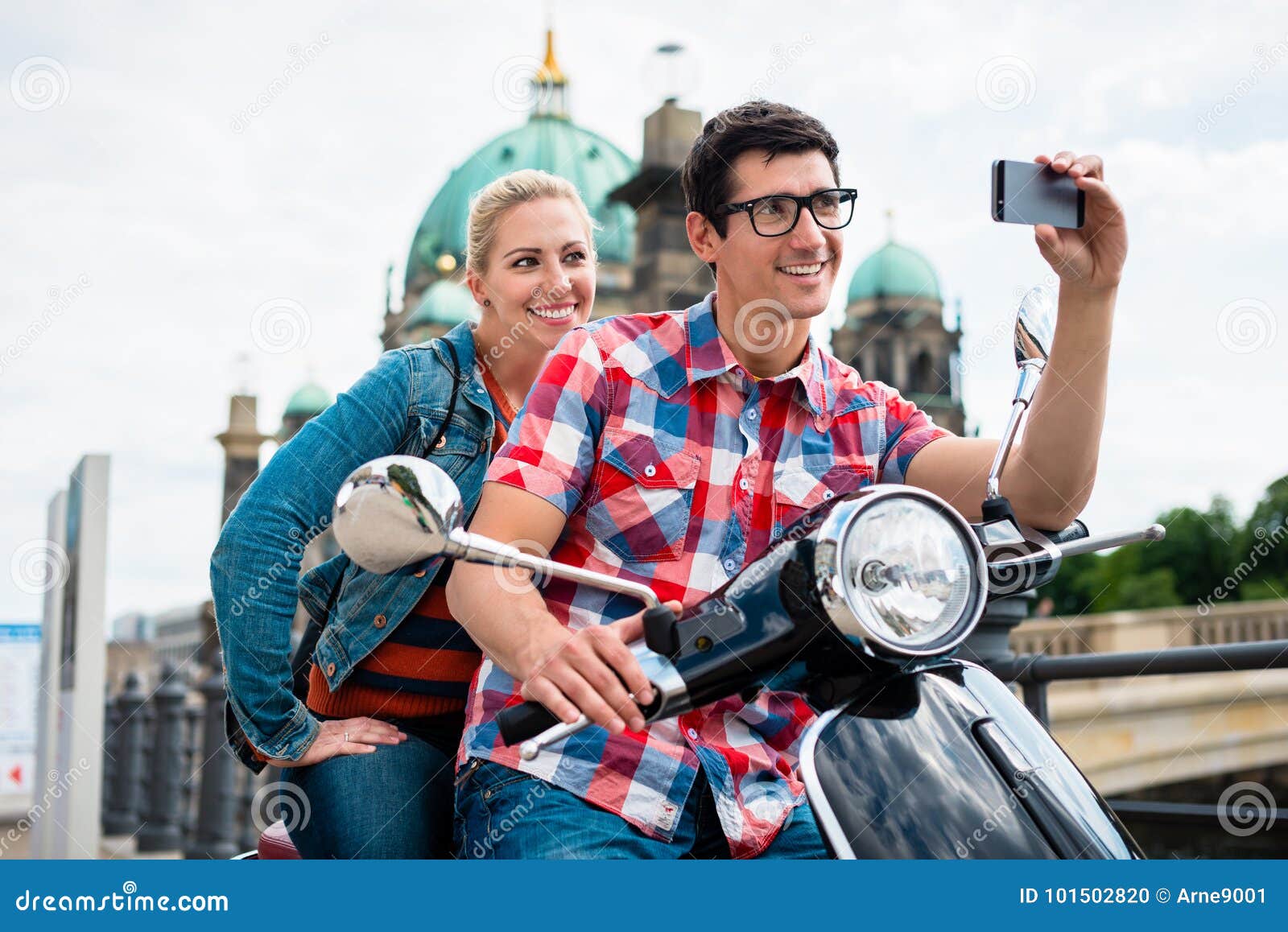 scooter riding tourists taking selfie in front of berlin cathedr