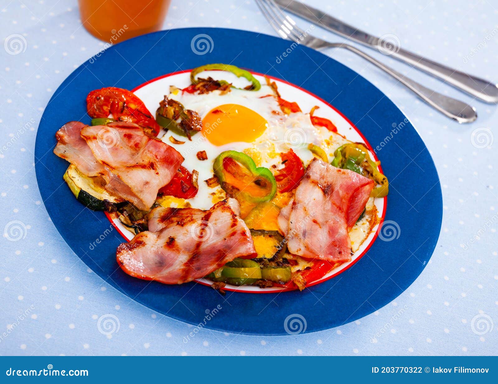 Scrambled Eggs with Bacon and Vegetables Served on Plate Stock Photo