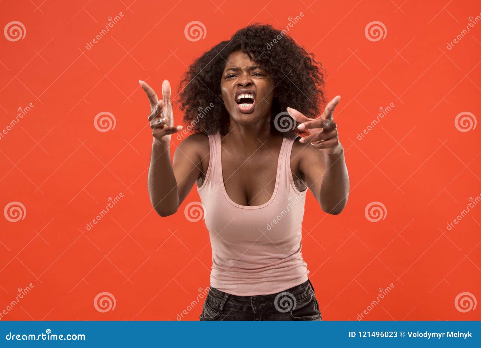 the young emotional angry woman screaming on red studio background