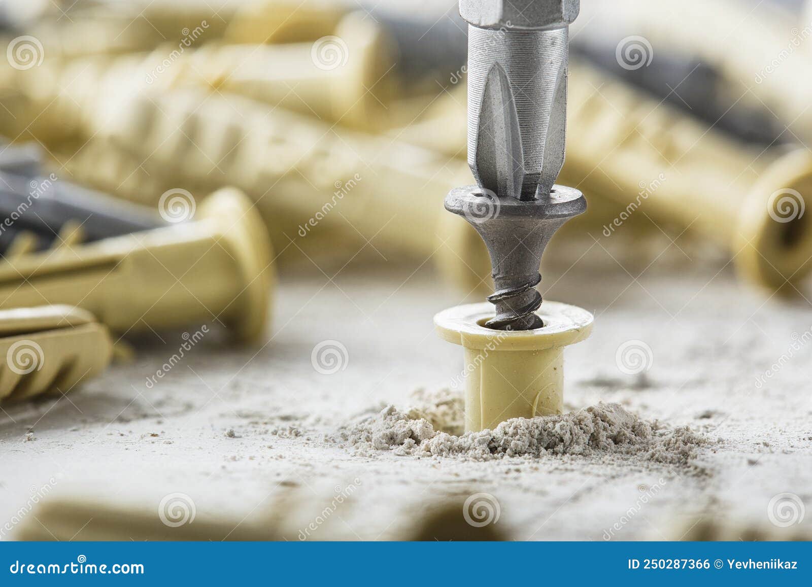 Screwdriver and Dowel in a Concrete Wall Background Stock Photo Image