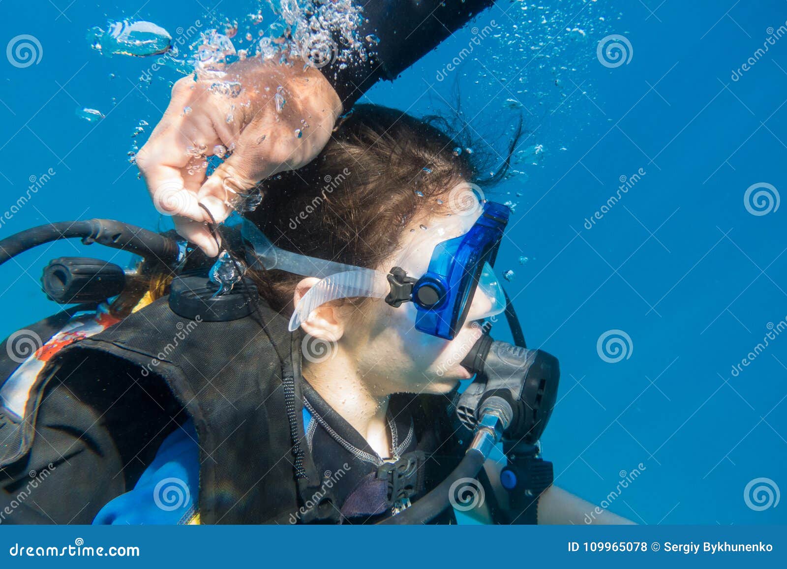 scuba instructor opened the air valve on wetsuit for immerse