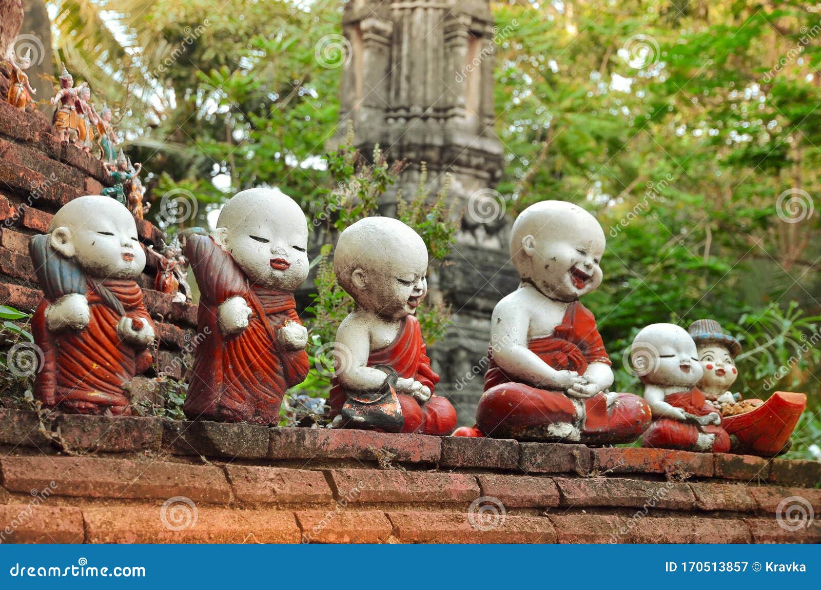 sculpture of little monks with bowls at the buddhists temple in ayutthaya
