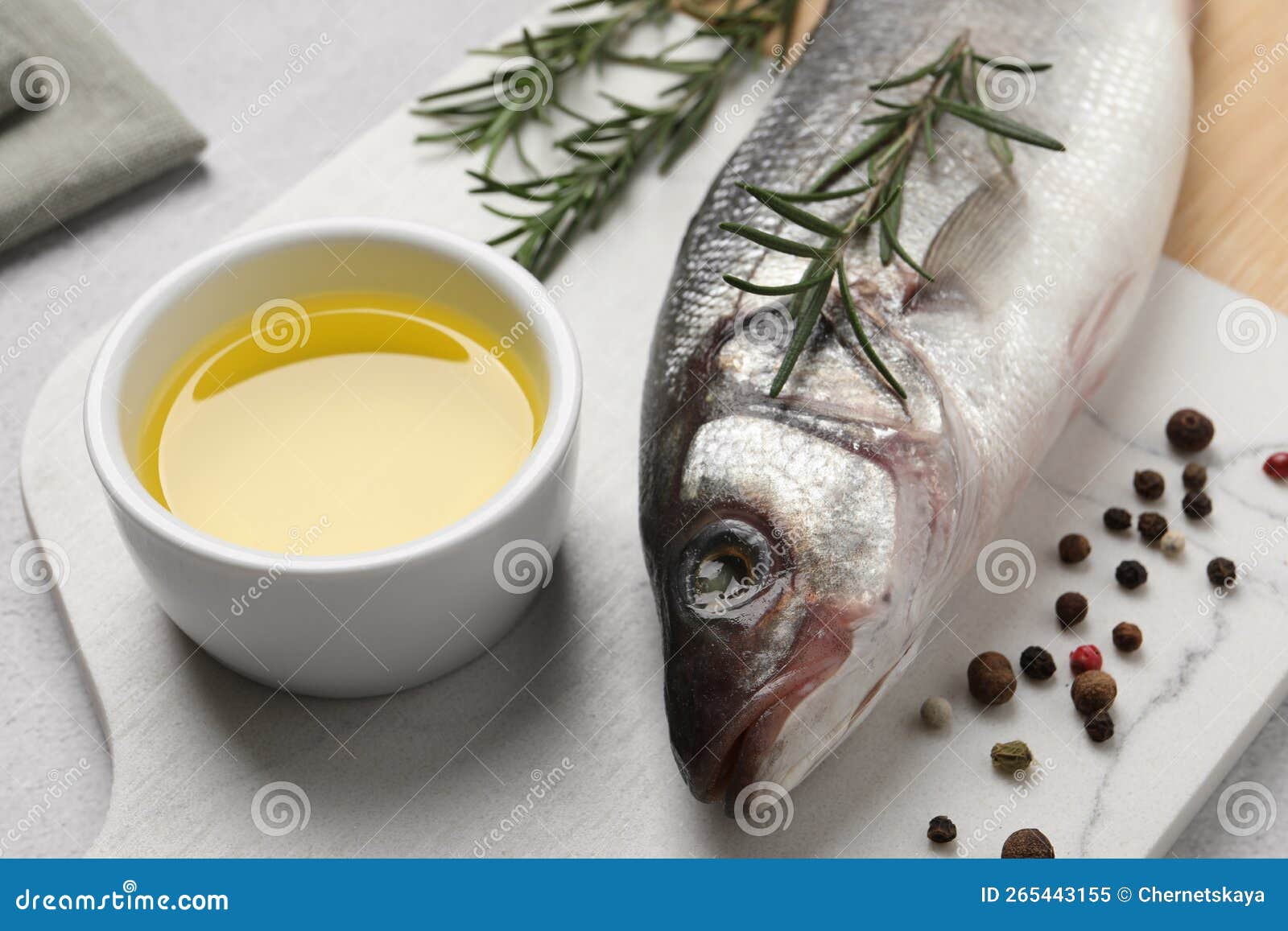 Sea Bass Fish and Ingredients on Light Grey Table, Closeup Stock Image