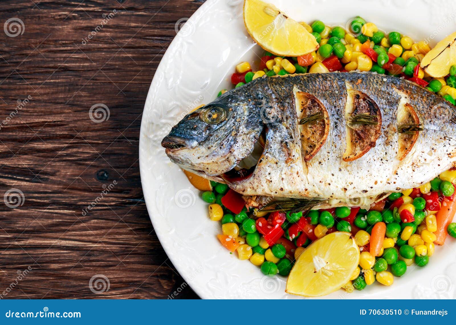 Sea Bream Baked with Herbs and Lemon, Vegetable Mix. Stock Photo