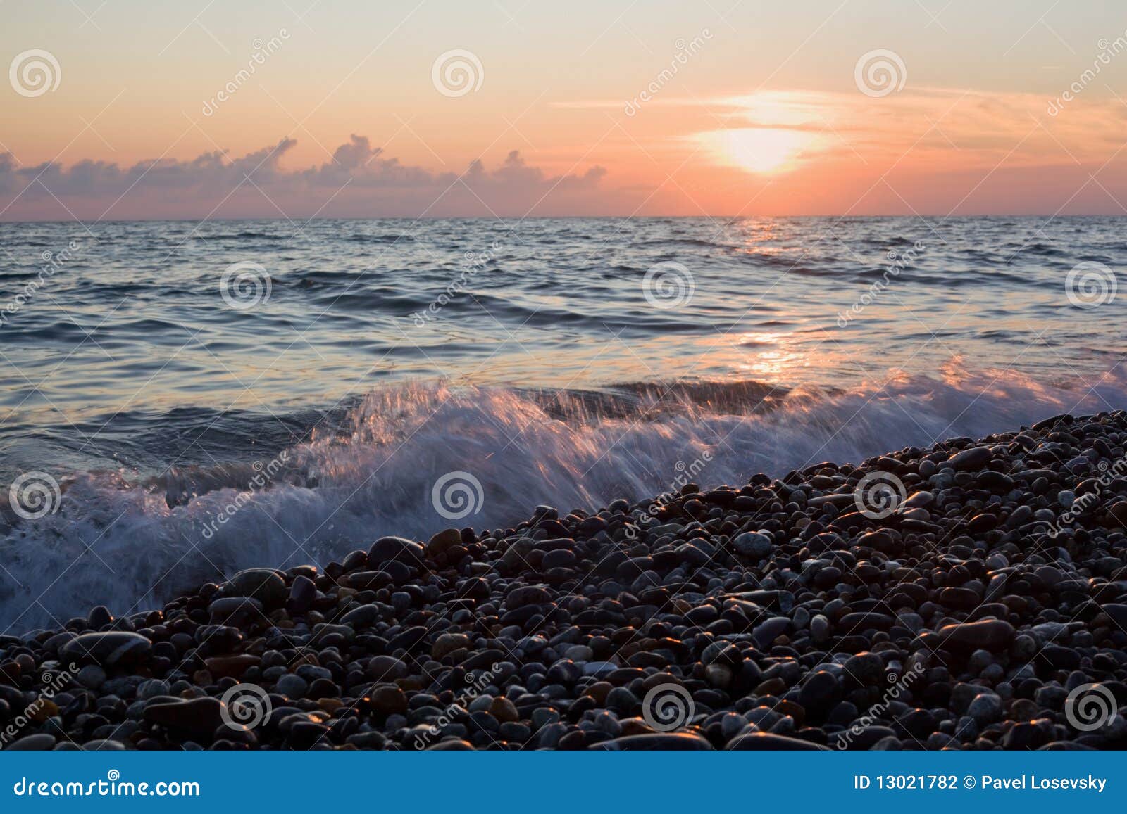 sea coast with waves on sunset, stony beach