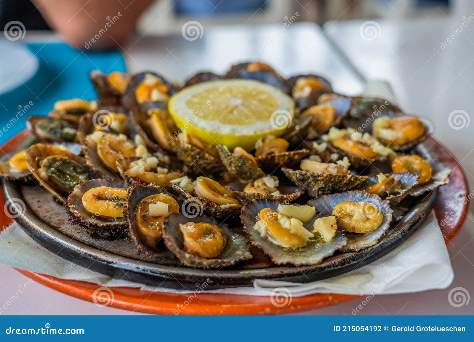 seafood - grilled limpets served with lemon. lapas grelhadas