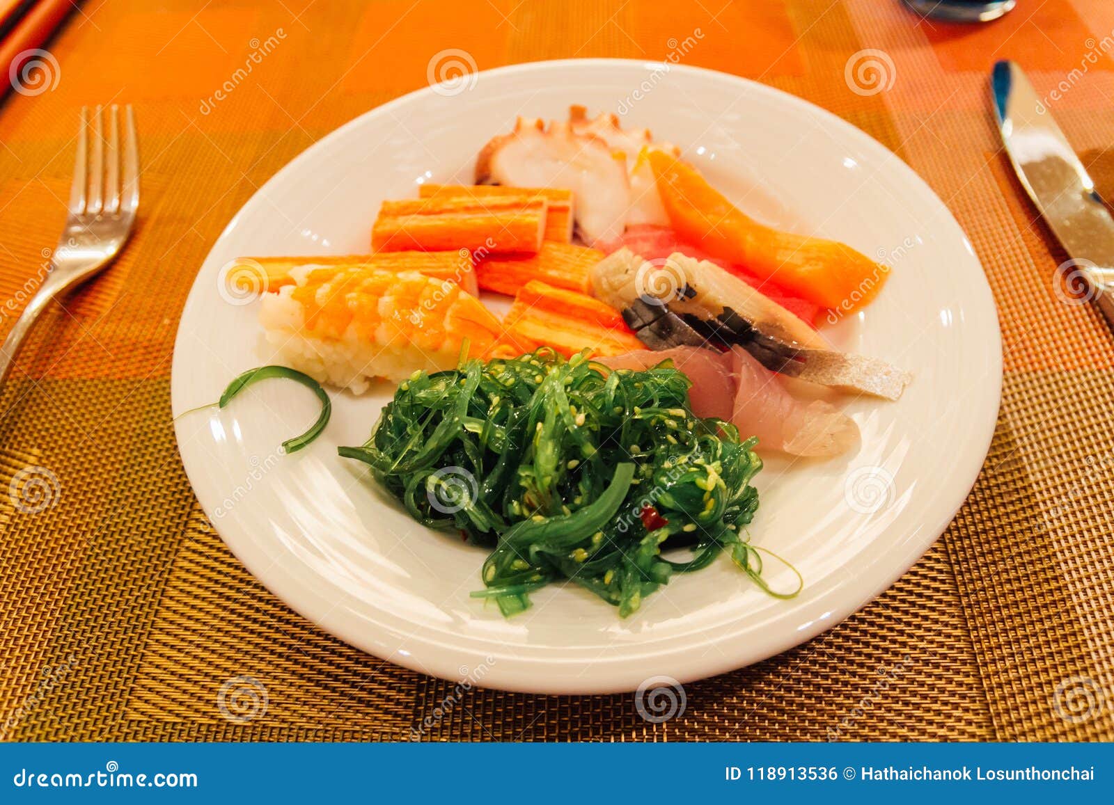 seafood japanesse dinner salmon, tuna, crab stick, sushi, seaweed on a plate at the hotel.