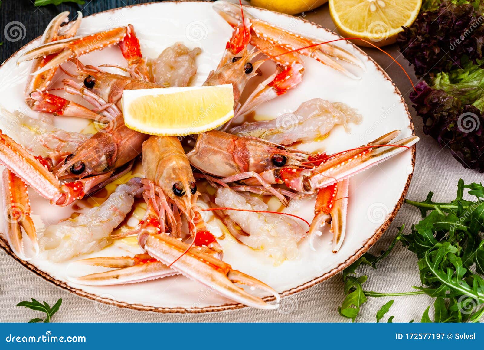 seafood. langoustine, scampi or norway lobster with lemon on white plate