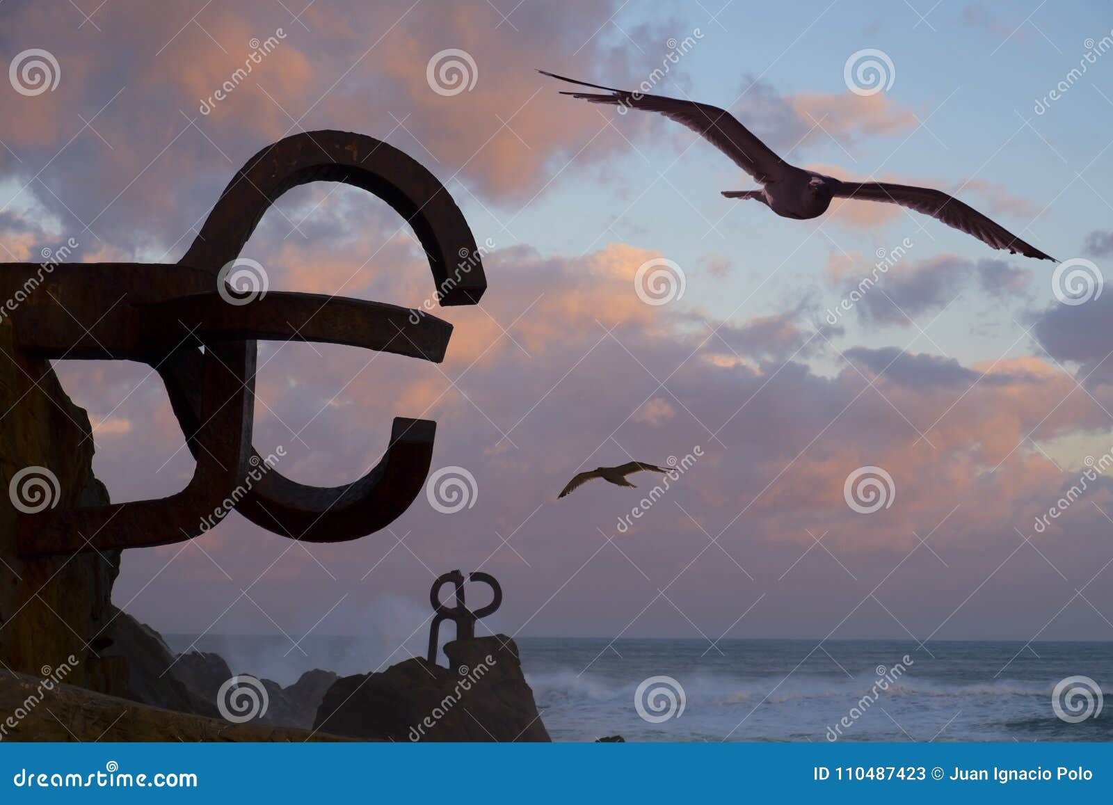 seagulls and sculpture `peine del viento` in san sebastian