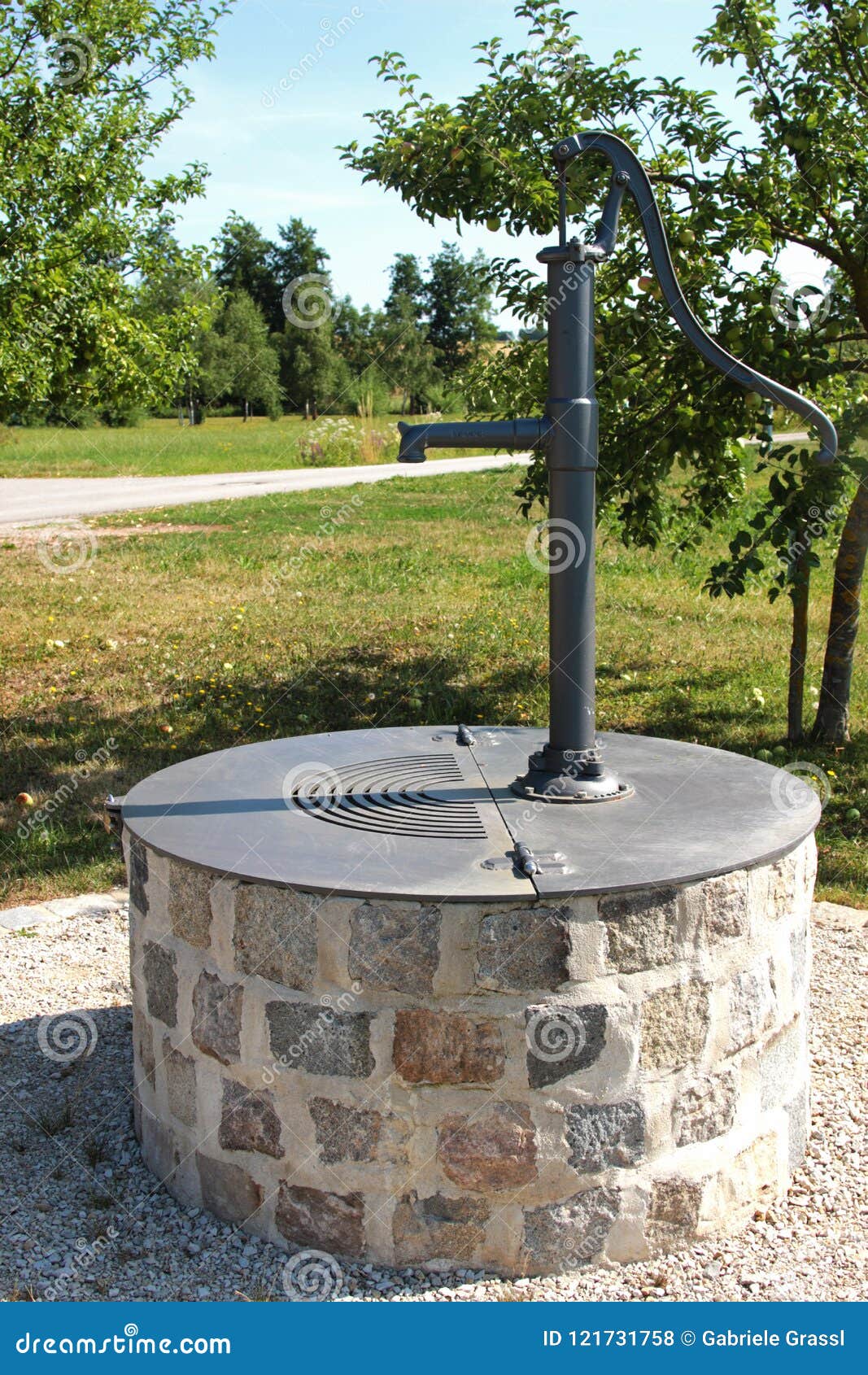 sealed wells with hand pump in an orchard