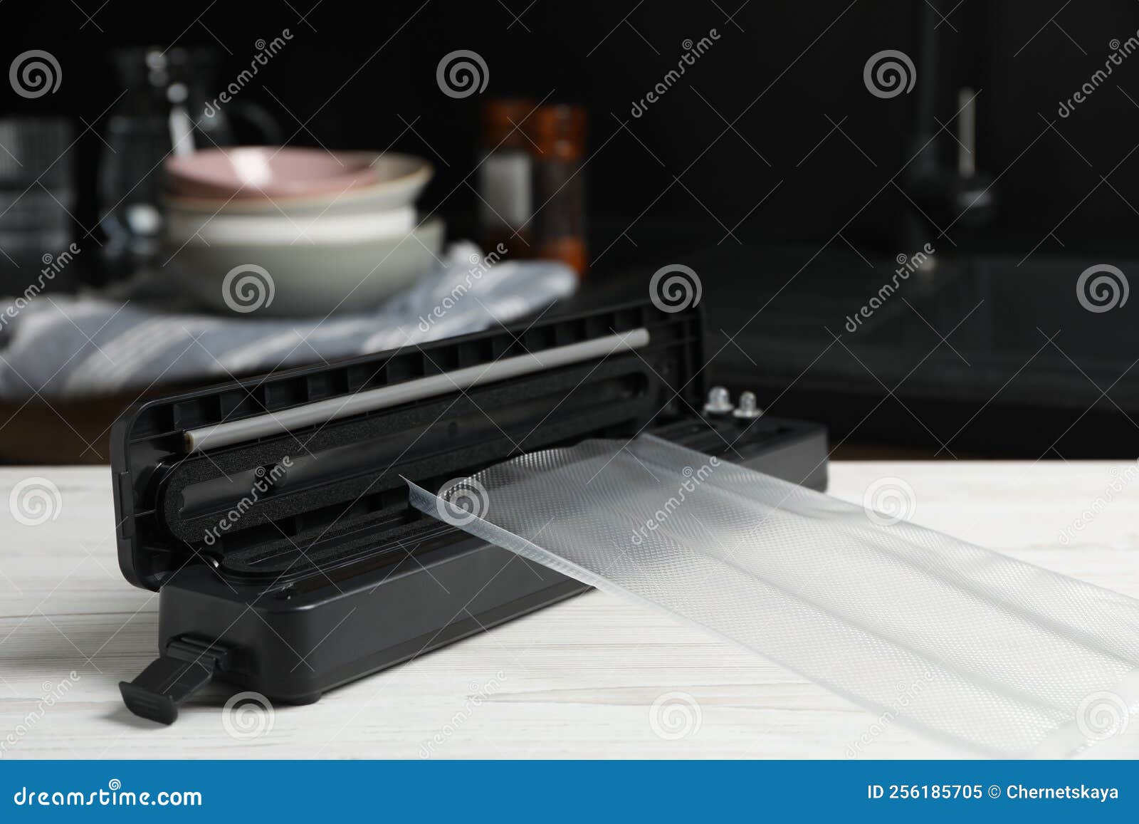 Sealer for Vacuum Packing with Plastic Bag on White Wooden Table in