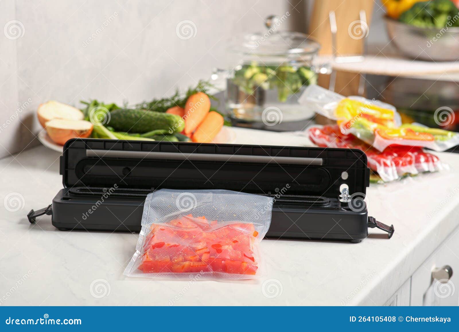 Sealer for Vacuum Packing with Red Pepper in Plastic Bag on White Table