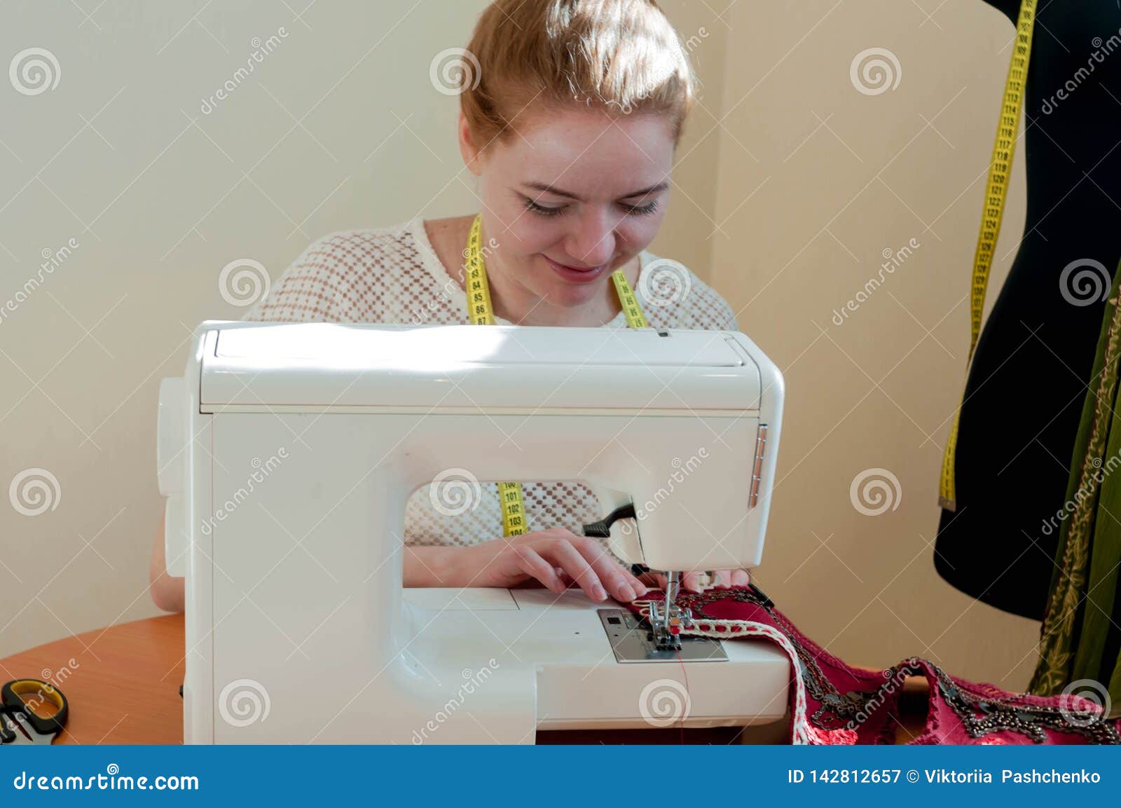 Seamstress Sitting at Sewing Machine and Working in Studio Stock Image