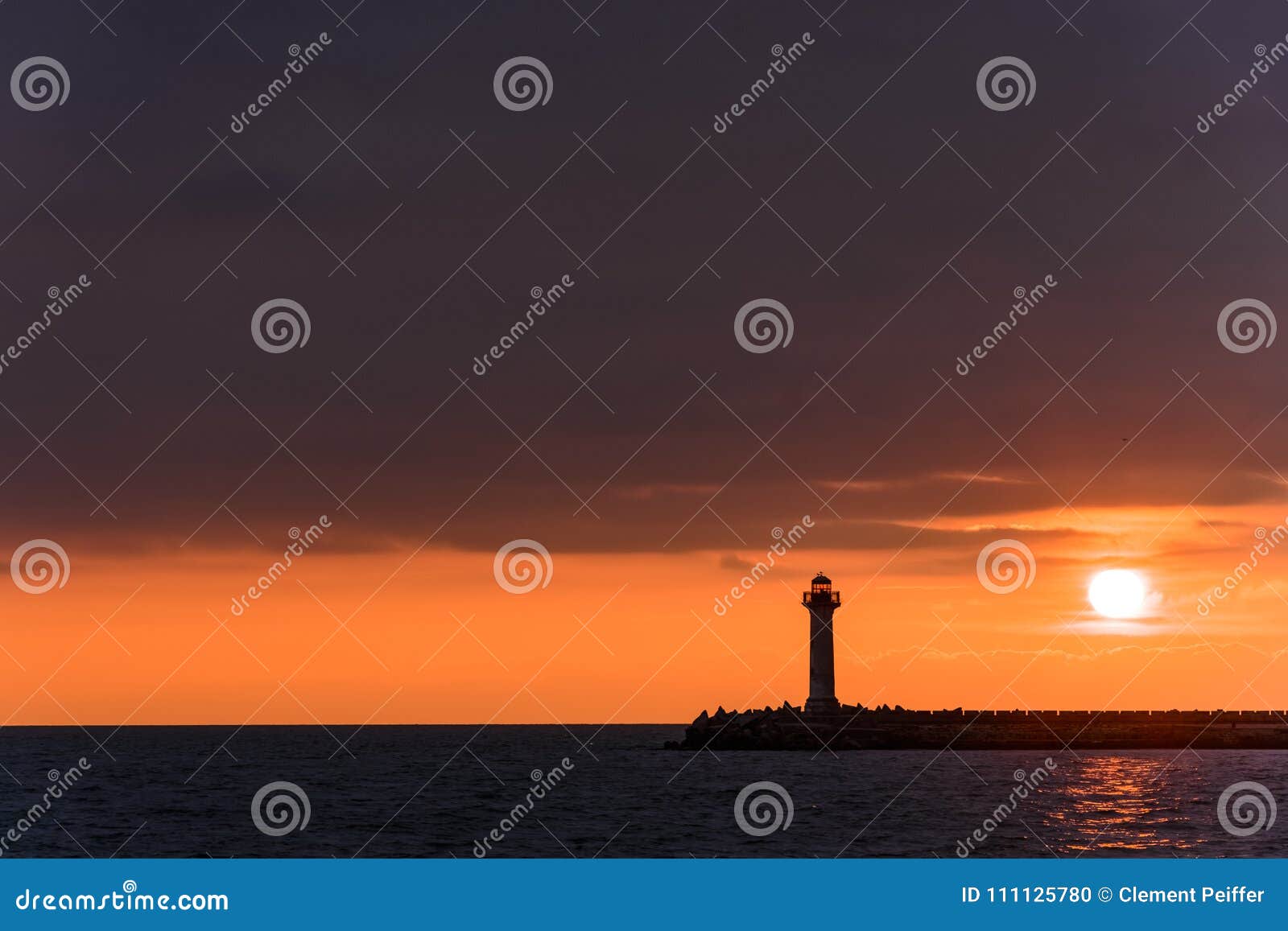 Seascape of a Lighthouse at Sunrise Against a Vibrant Orange Sky Stock ...