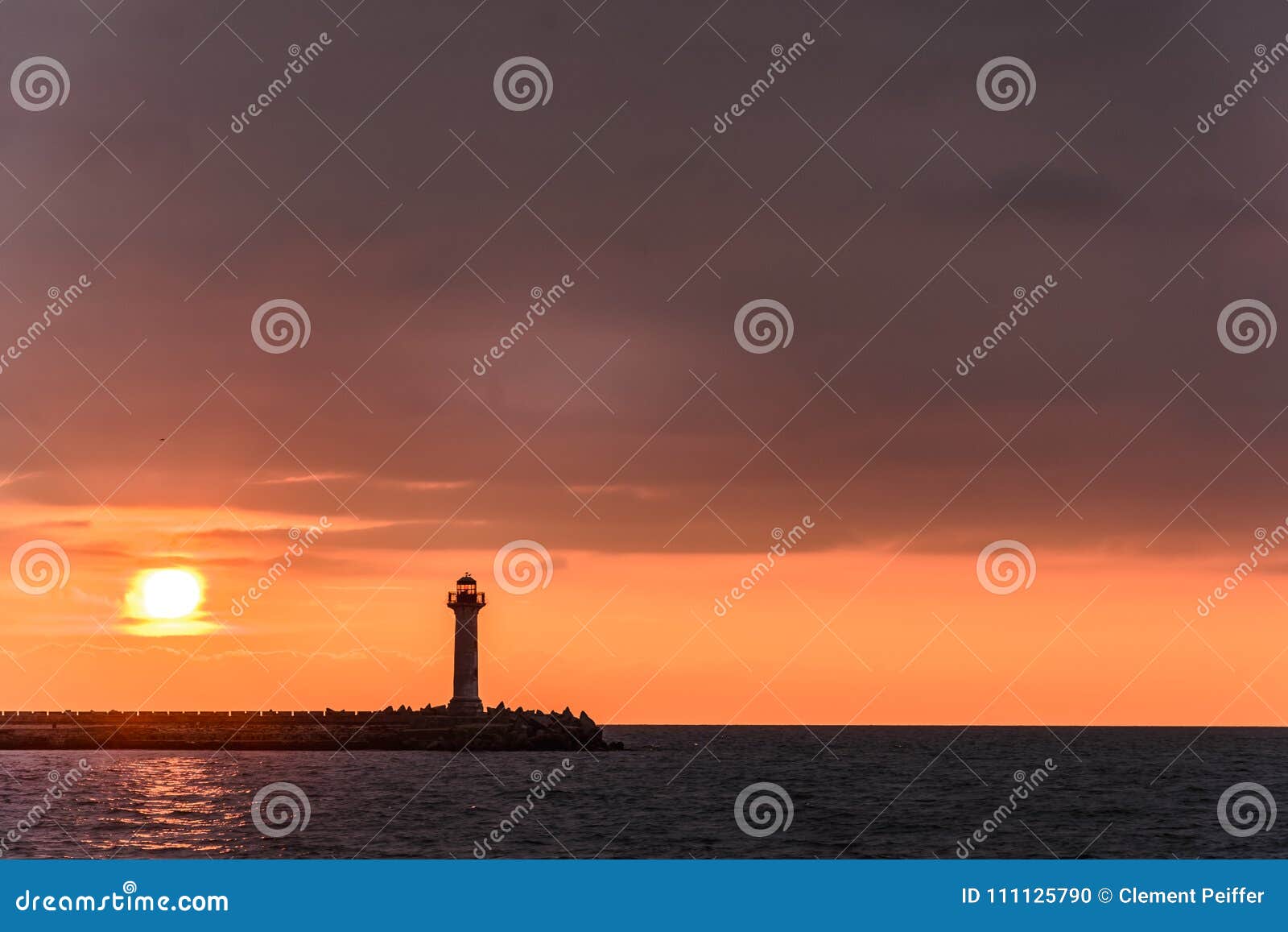 Seascape of a Lighthouse at Sunrise Against a Vibrant Orange Sky Stock ...