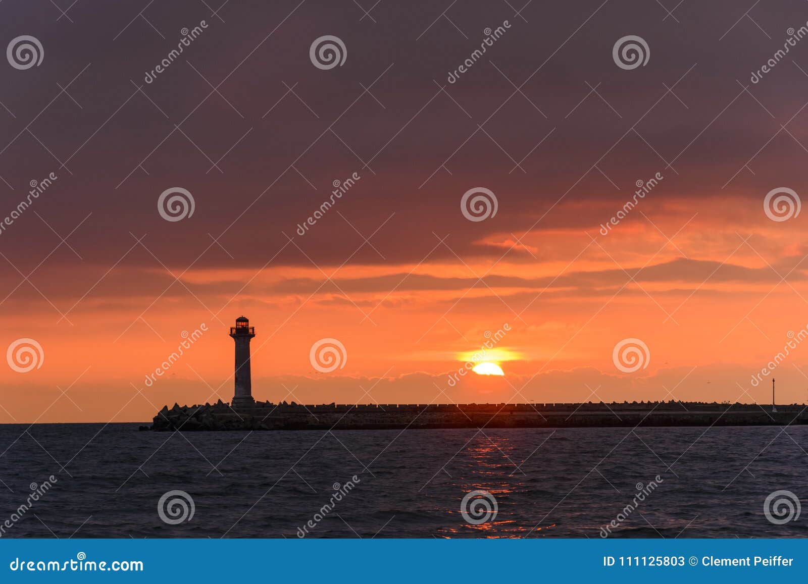 Seascape of a Lighthouse at Sunrise Against a Vibrant Orange Sky Stock ...