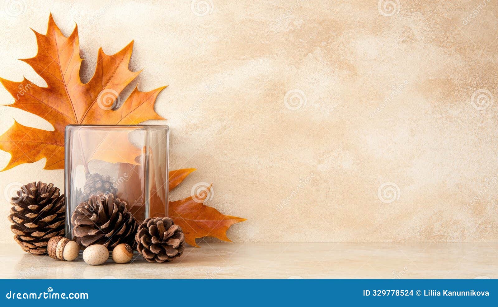 a seasonal display features autumn leaves, pinecones, and acorns arranged in a glass jar on a wooden table, capturing