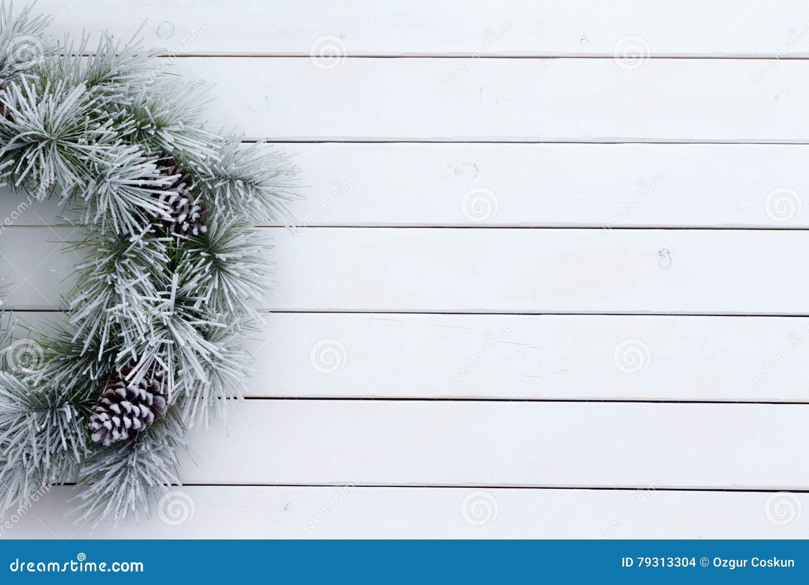 Christmas small green wreath with cones at wood board. Copy space