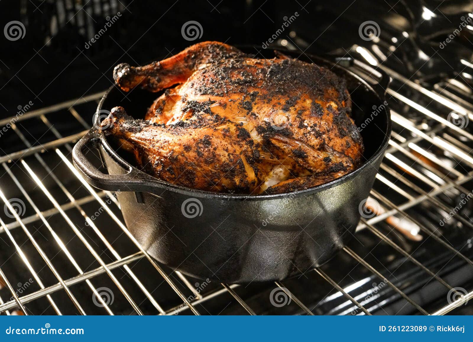 Seasoned Whole Chicken Roasting in Cast Iron Pot in Oven Stock Image