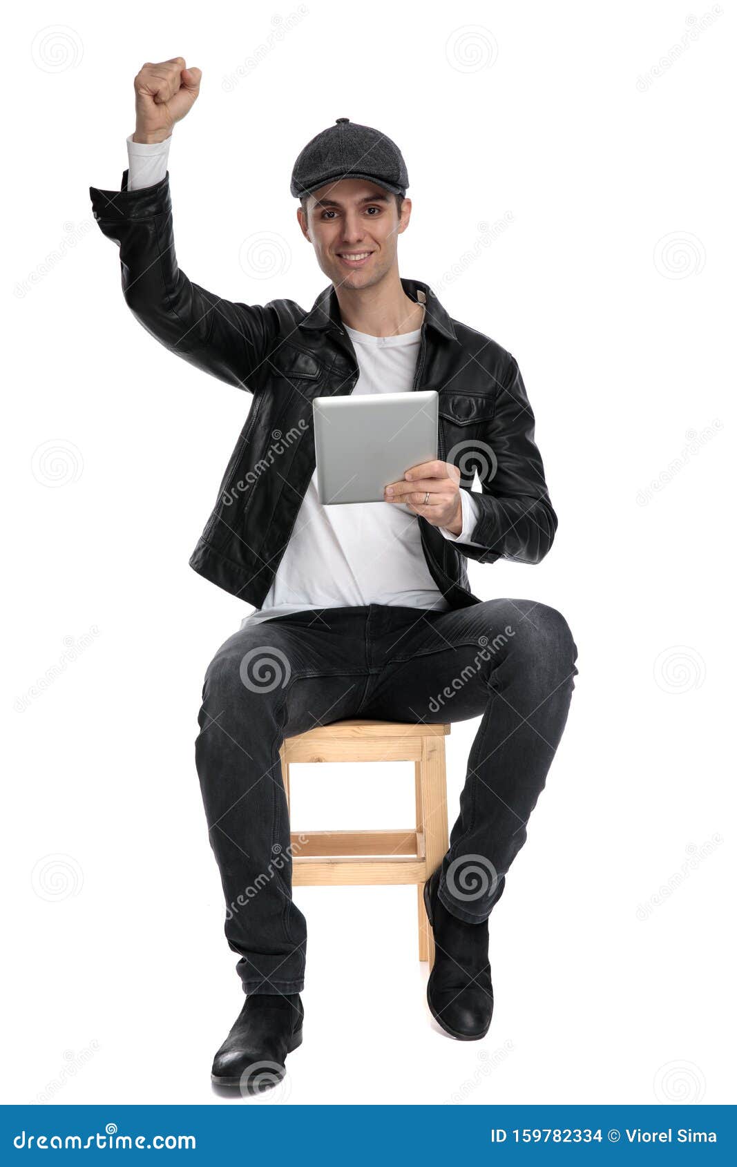 seated casual man with tablet raising fist victoriously