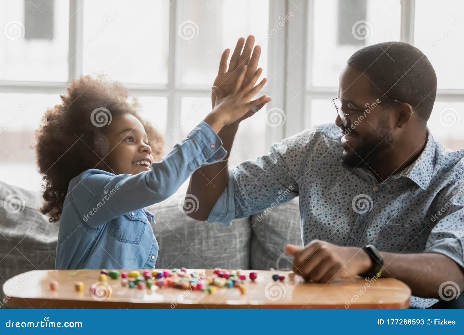 african daughter gives high five to father starting pastime activity