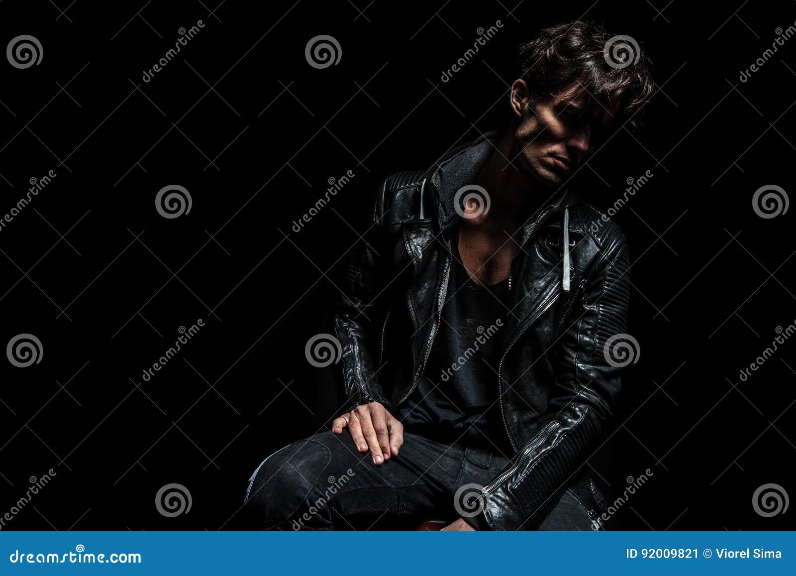 Seated Fashion Model Wearing Leather Jacket and Looking Away Stock ...
