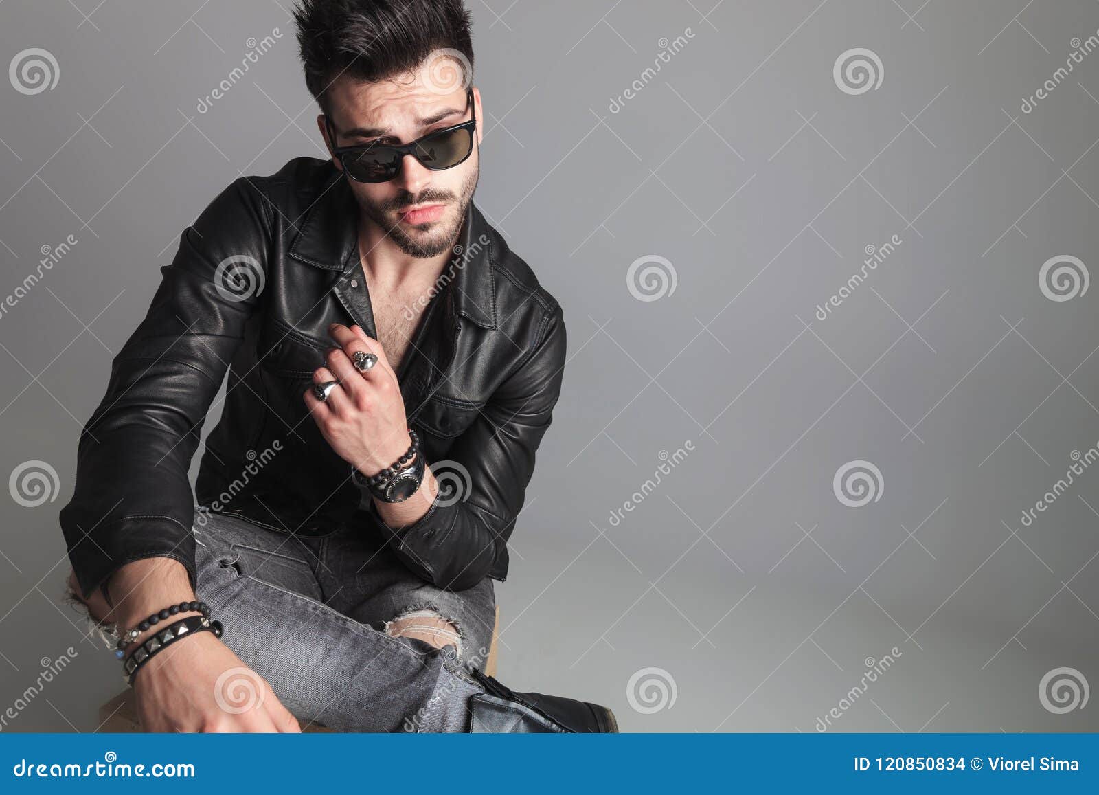 Seated Man Wearing Sunglasses and Leather Jacket Looks To Side Stock ...