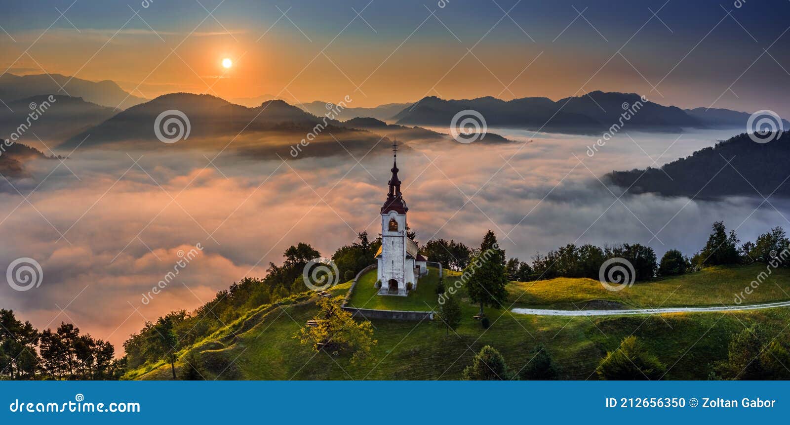 sebrelje, slovenia - aerial panoramic drone view of the beautiful hilltop church of st.ivan sv. ivan cerkev at sunrise with fog