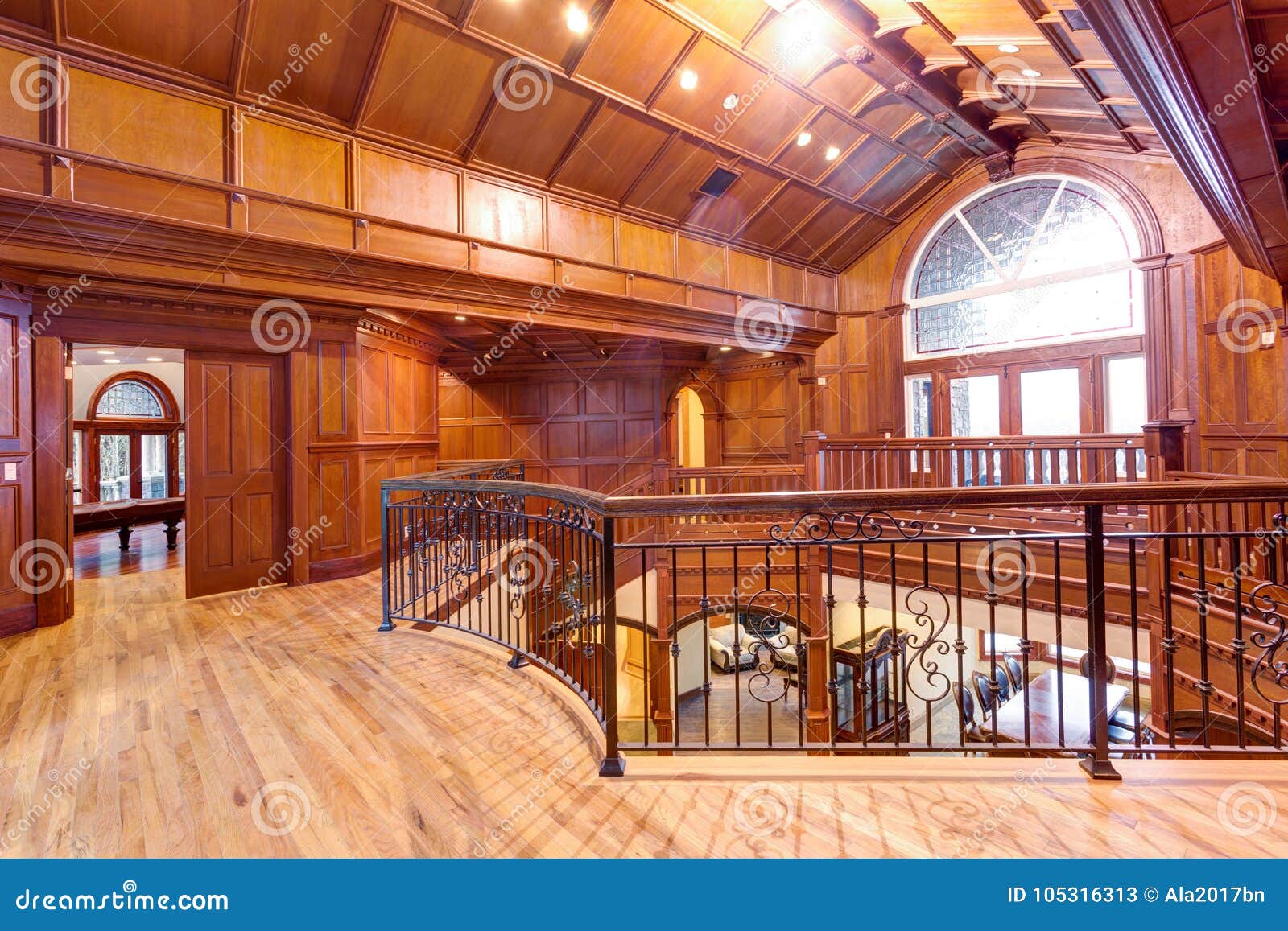 Second Floor Landing Accented With Wood Paneled Walls And