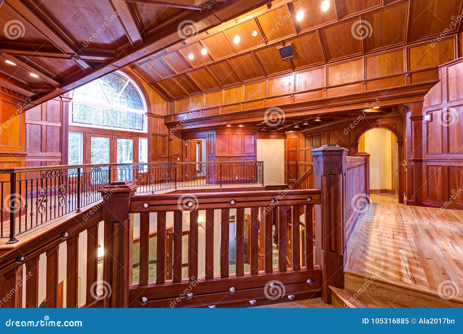 Second Floor Landing Accented With Wood Paneled Walls And