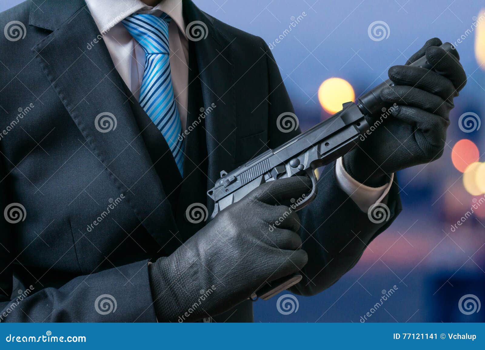 secret agent holds pistol with silencer in hands at twilight