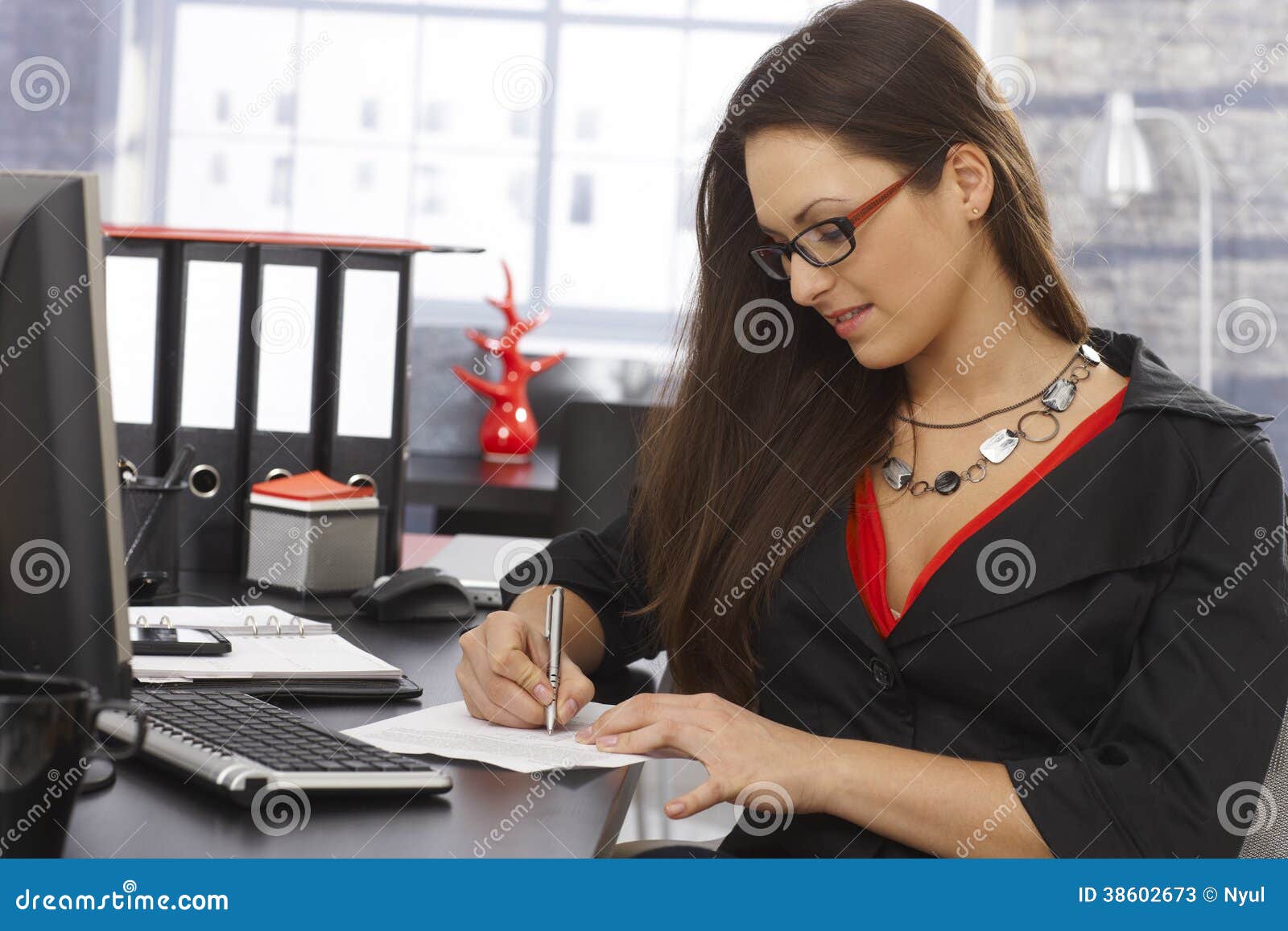 secretary writing notes at desk