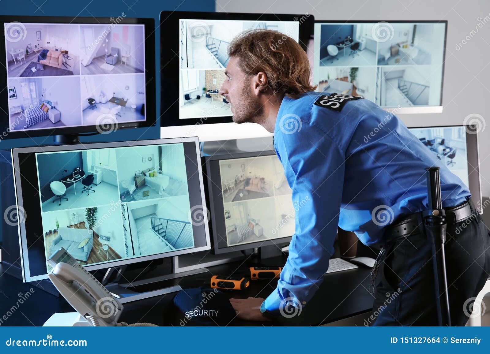 Security Guard Monitoring Modern CCTV Cameras In Surveillance Room