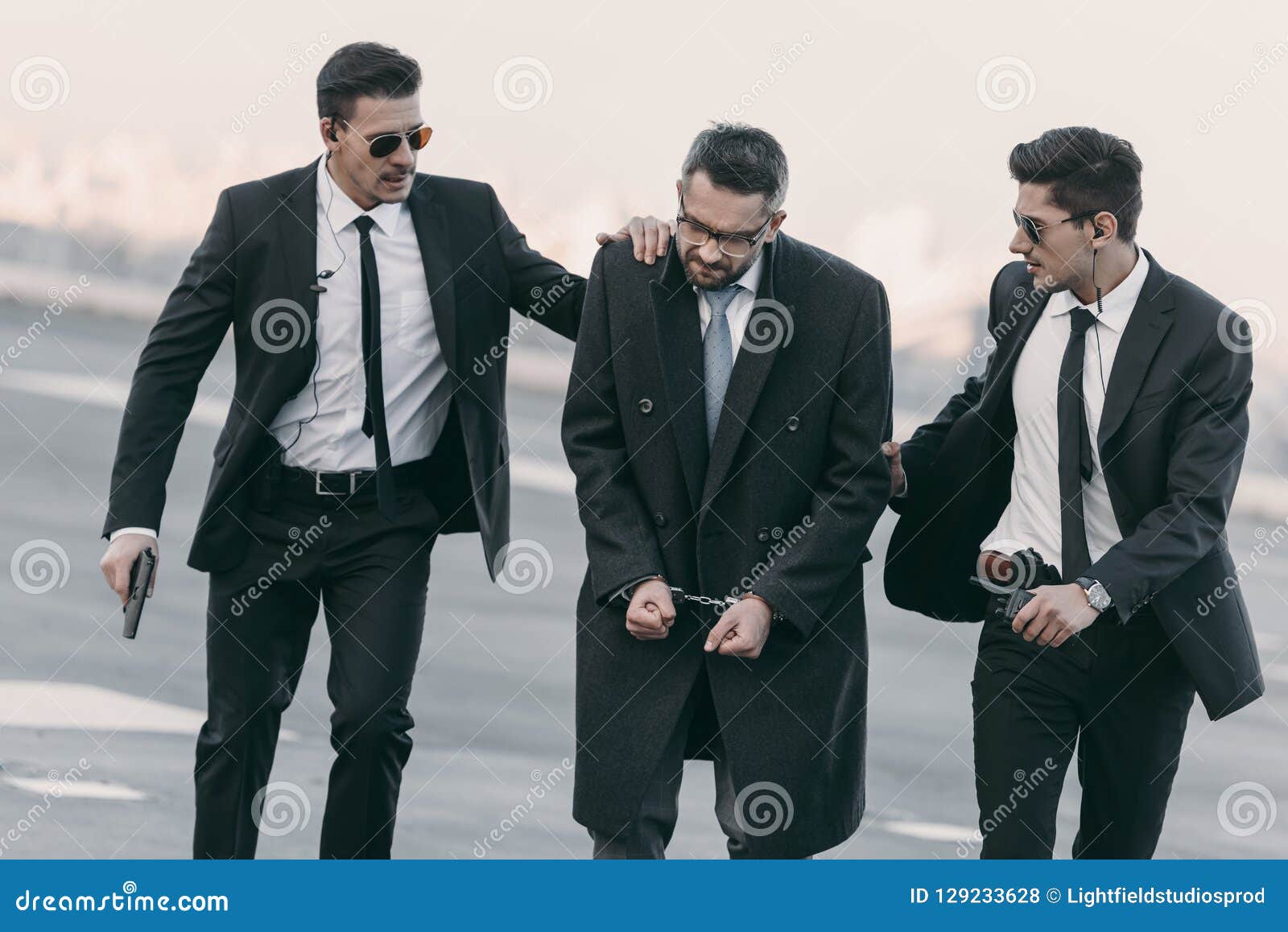 security guards with weapon standing with arrested man